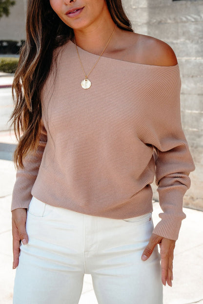Woman wearing Cozy Ribbed Boat Neck Sweater in camel and white pants, accessorized with a gold pendant necklace outdoors.