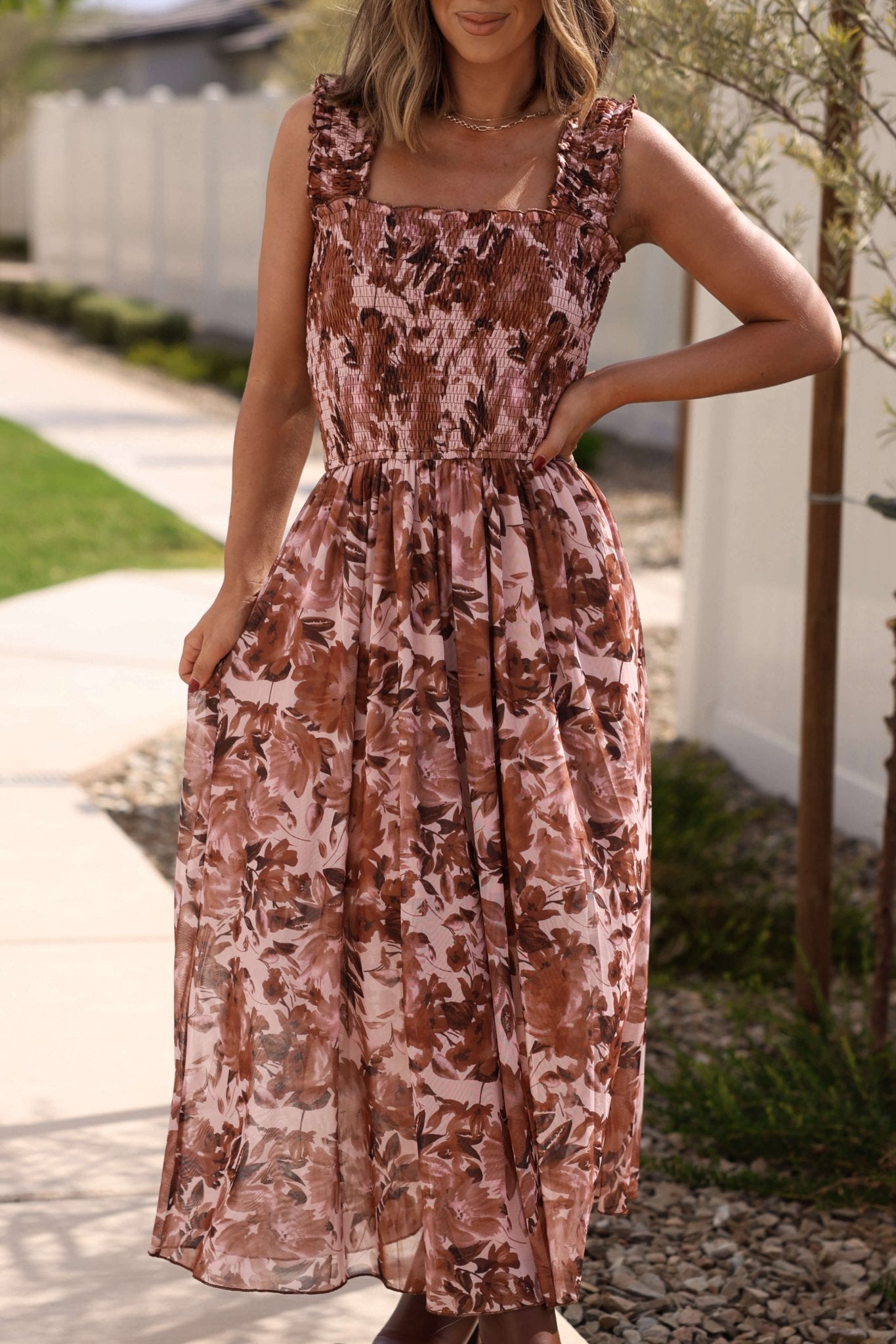 Woman in the Drifter Brown Floral Print Tiered Maxi Dress stands outdoors, showcasing chic fall style.