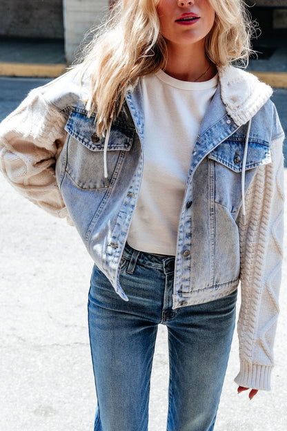 Woman wearing the Elan Denim Hooded Sweater Jacket with cable knit sleeves—a perfect transitional layer on a sunny day.