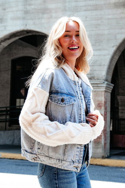 A woman with blonde hair smiles outdoors, wearing the Elan Denim Hooded Sweater Jacket—a perfect transitional layer.