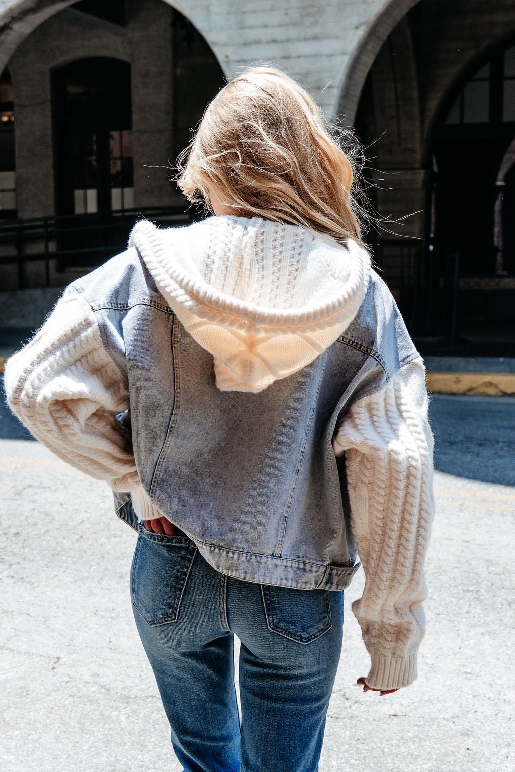 Blonde woman wears the Elan Denim Hooded Sweater Jacket, a perfect transitional layer, while standing outdoors.