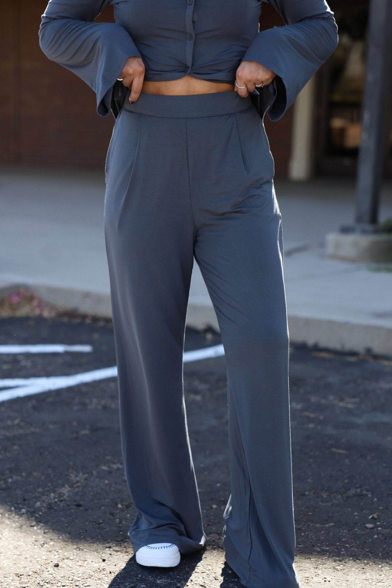 Wearing Elan Grey Flowy Wide Leg Pants -DOORBUSTER, perfect for a chic fall look, standing on pavement.