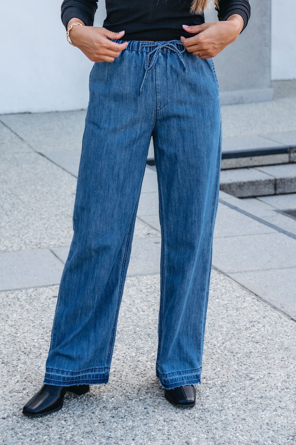 A person wearing Elan Medium Wash Wide Leg Pants with an elastic waistband.