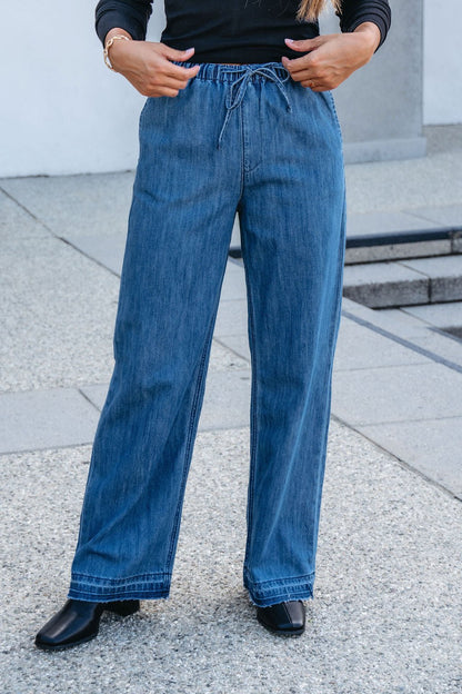 A person wearing Elan Medium Wash Wide Leg Pants with an elastic waistband.