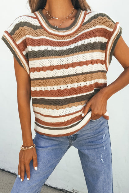 Woman wearing the Field Day Stripe Sweater Vest - Olive with blue jeans, posing with one hand on her hip.