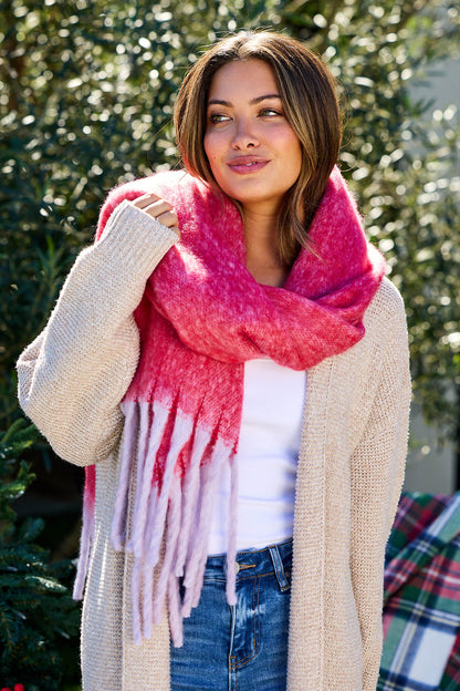 Woman outdoors in a beige cardigan and white top, smiling in a Fluffy Red Ombre Fringe Blanket Scarf—must-have winter accessory.