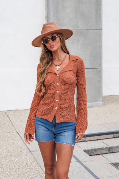 Woman in a brown hat, sunglasses, The Marisol Crochet Top - Terracotta, and denim shorts stands by a white wall and concrete steps.