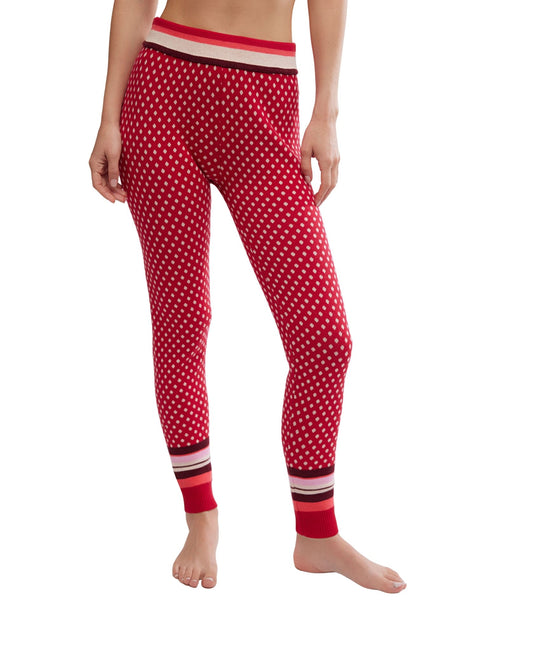 Person wears Free People Falala Red Peppermint Dot Leggings with striped waistband and cuffs, standing barefoot against a white background.