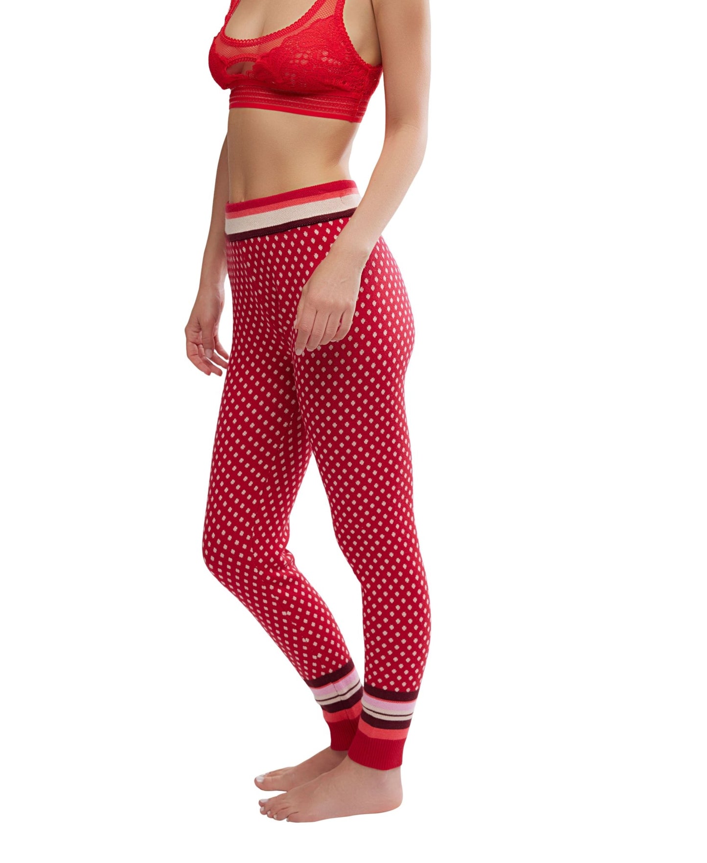 Woman wears Free People Falala Red Peppermint Dot Leggings and a matching bralette, standing barefoot against a white background.