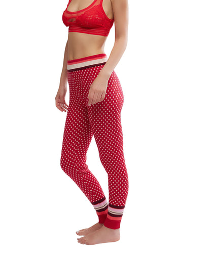 Woman wears Free People Falala Red Peppermint Dot Leggings and a matching bralette, standing barefoot against a white background.
