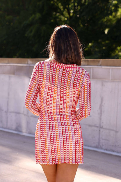 A woman stands outdoors with her back to the camera in the Fuchsia Multi Striped Crochet Mini Dress - FINAL SALE.