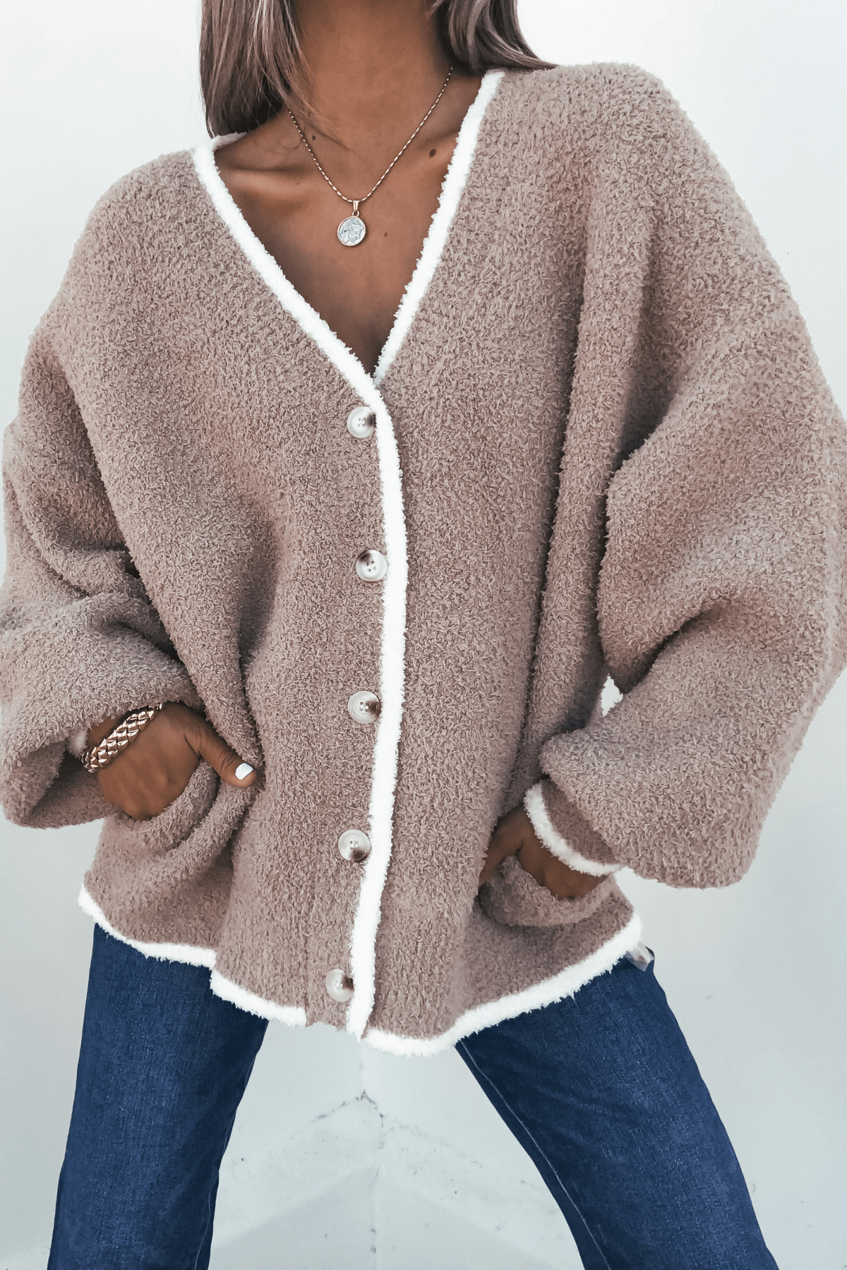 Model wears the Fuzzy Soft Camel Button Down Cardigan with white trim, styled with blue jeans and gold jewelry.
