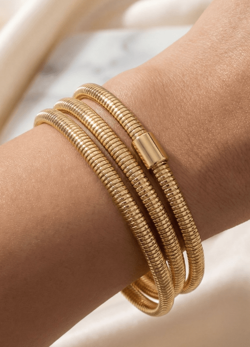 The Gold Coiled Metallic Bracelet Set wraps three times around the wrist, adding a chic, layered shine to your look.