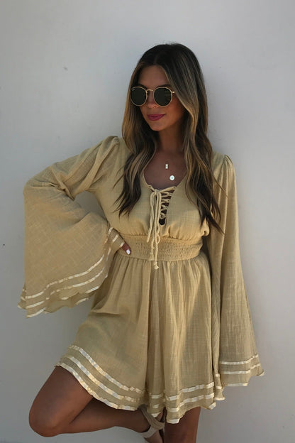 Woman in the Golden Hour Bell Sleeve Romper with sunglasses, posing against a plain white background.
