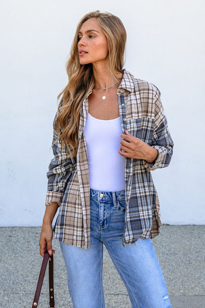 Woman with long blonde hair in a Grey Plaid Button Down Top, white tank, light blue jeans, holding a brown strap outdoors.