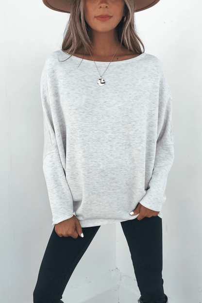 Woman in a wide-brim hat, Grey Soft Cloud Scuba Pullover, and black pants standing against a plain white background.