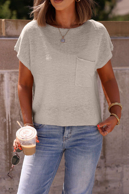 Woman in the Haven Natural Cap Sleeve Sweater and jeans holds iced coffee, sunglasses, standing outdoors with a hand in her pocket.