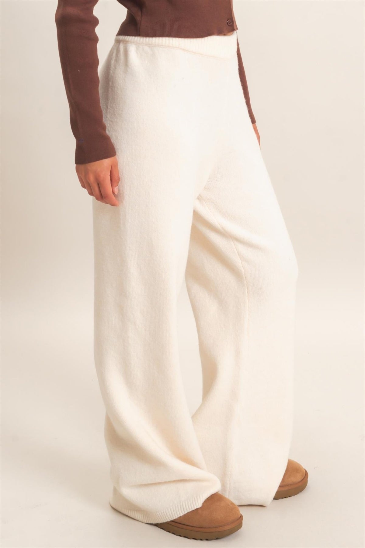 HYFVE DZ26E640 CREAM WIDE LEG PANTS in cream, worn with a brown long-sleeve top and brown slip-on shoes.
