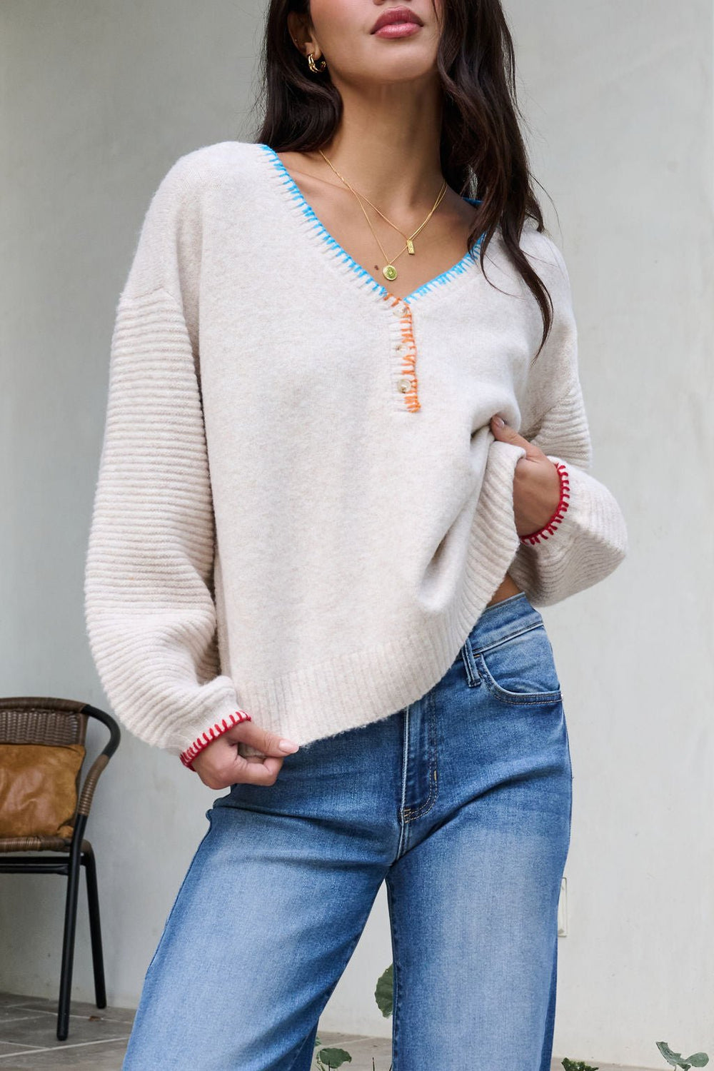Woman wearing the Ivory Stitch Trim Button Up Sweater - FINAL SALE with colorful accents and blue jeans, standing indoors.