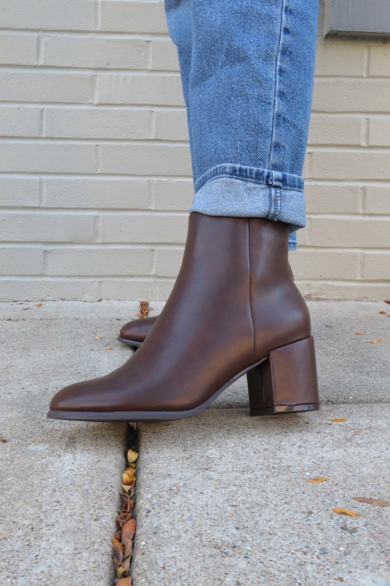 Wearing cuffed blue jeans and Jalen Brown Faux Leather Booties with block heels—ideal for your fall wardrobe.