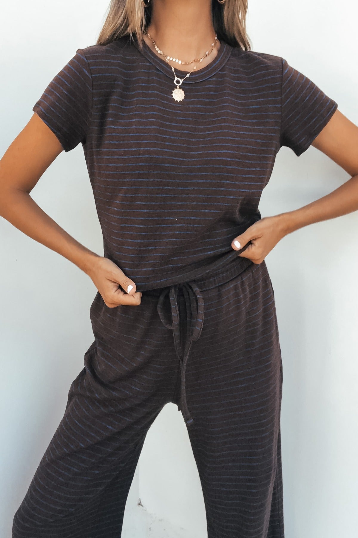 Woman wearing the Kacey Striped Short Sleeve Top in brown, posing with hands on hips.