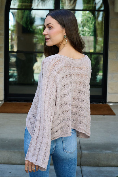 Woman wearing the Laurel Taupe Open Knit Sweater stands outside, looking over her shoulder.