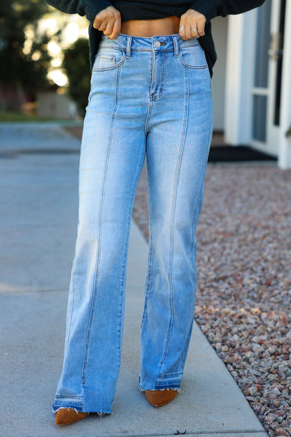 Person wearing Light Wash Seam Detail Wide Leg Jeans with brown pointed-toe shoes, standing stylishly on a city sidewalk.