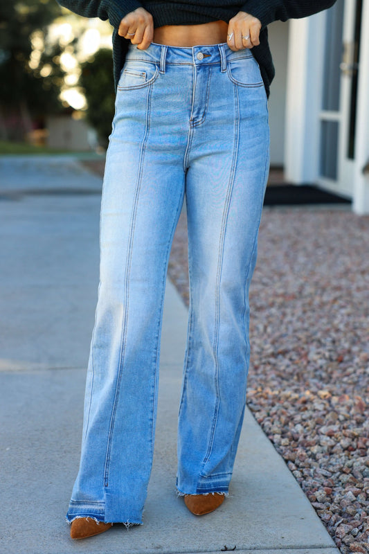 Person wearing Light Wash Seam Detail Wide Leg Jeans with brown pointed-toe shoes, standing stylishly on a city sidewalk.