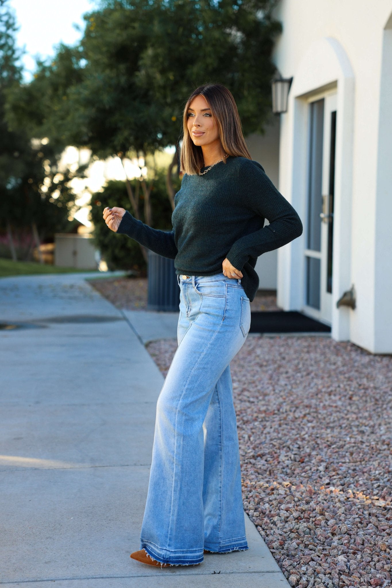 Woman outdoors in front of a building, wearing a dark sweater, Light Wash Seam Detail Wide Leg Jeans, and brown shoes.
