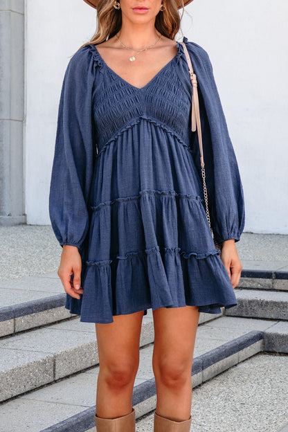 Long Sleeve Smocked Mini Dress - Navy in a long-sleeve smocked mini style with a tiered ruffle skirt.