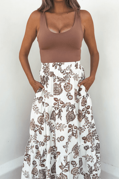 Model wears Lorelei Brown Floral Print Midi Skirt with a sleeveless top, standing against a white background.