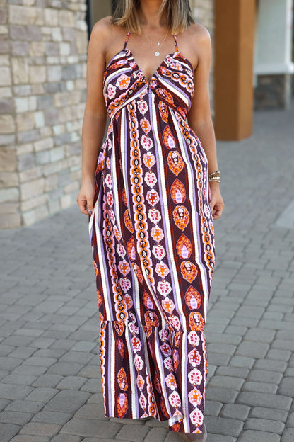 Woman in the Maple Moments Halter Maxi Dress - Multi - DOORBUSTER, with a deep halter V-neck, on a cobblestone walkway.