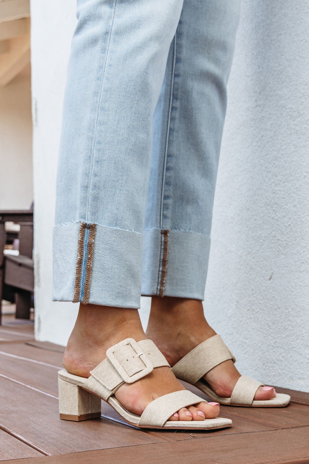 A person stands on a wooden floor wearing light-wash jeans and Matisse Lakelynn Natural Linen Block Heels - FINAL SALE.