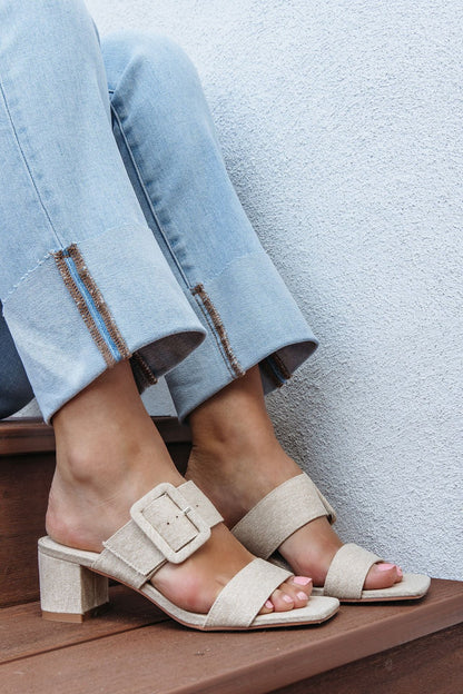 Close-up of feet in Matisse Lakelynn Natural Linen Block Heels, paired with light blue jeans on wooden steps. Final Sale.