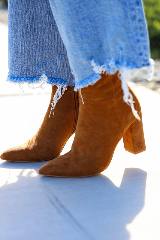 Close-up of Matisse Spencer Camel Heeled Ankle Booties styled with frayed hem blue jeans on a sunny day.