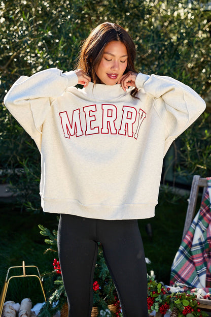 Woman outdoors in a Merry Grey Oversized Sweatshirt - FINAL SALE and black leggings, with festive holiday decor nearby.