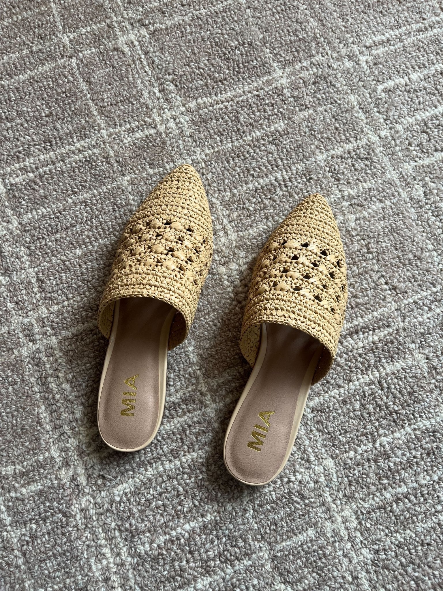 A pair of MIA Jany Natural Pointed Mules sits on a textured gray carpet.