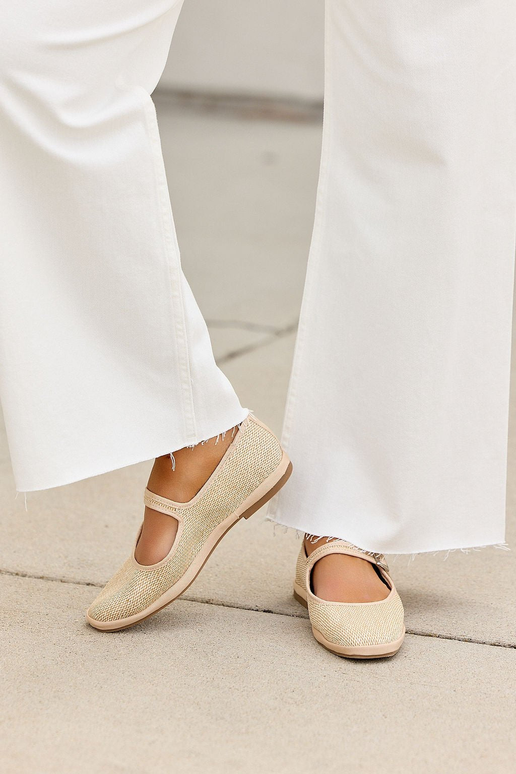 Individual in frayed white pants and MIA Monroe Ballet Flats - Natural, standing on a light concrete surface.
