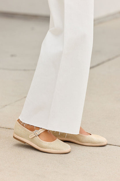 Person in white wide-leg pants and MIA Monroe Ballet Flats - Natural, standing on light pavement.