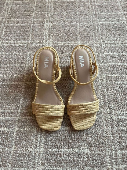 A pair of MIA Zissy Natural Strappy Heels sits on a textured tan carpet.