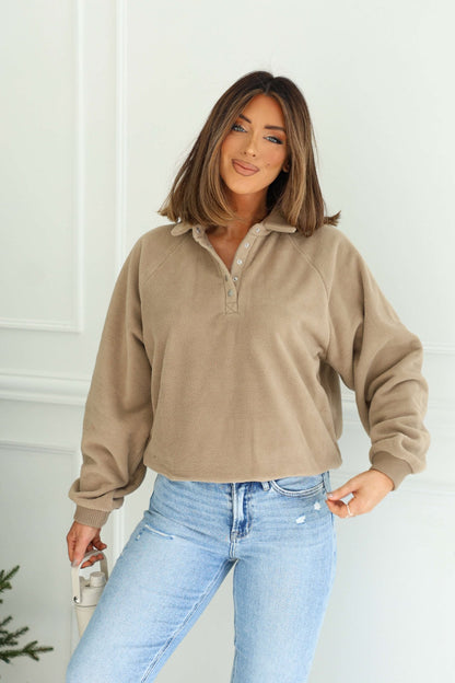 Woman with shoulder-length brown hair wearing a Mocha Button Up Fleece Pullover and light blue jeans, smiling indoors.