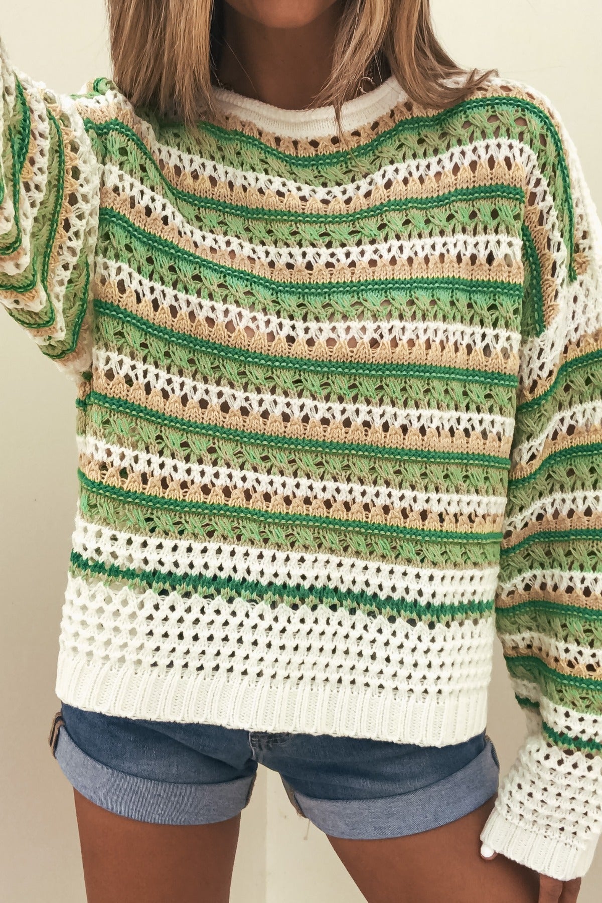 Wearing a Multi Green Striped Boatneck Sweater and blue denim shorts for a cozy, casual look.