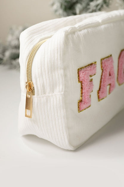 A Multi Mix Patch Make Up Bag with gold zipper and pink sequin letters “FAC” on a white surface.
