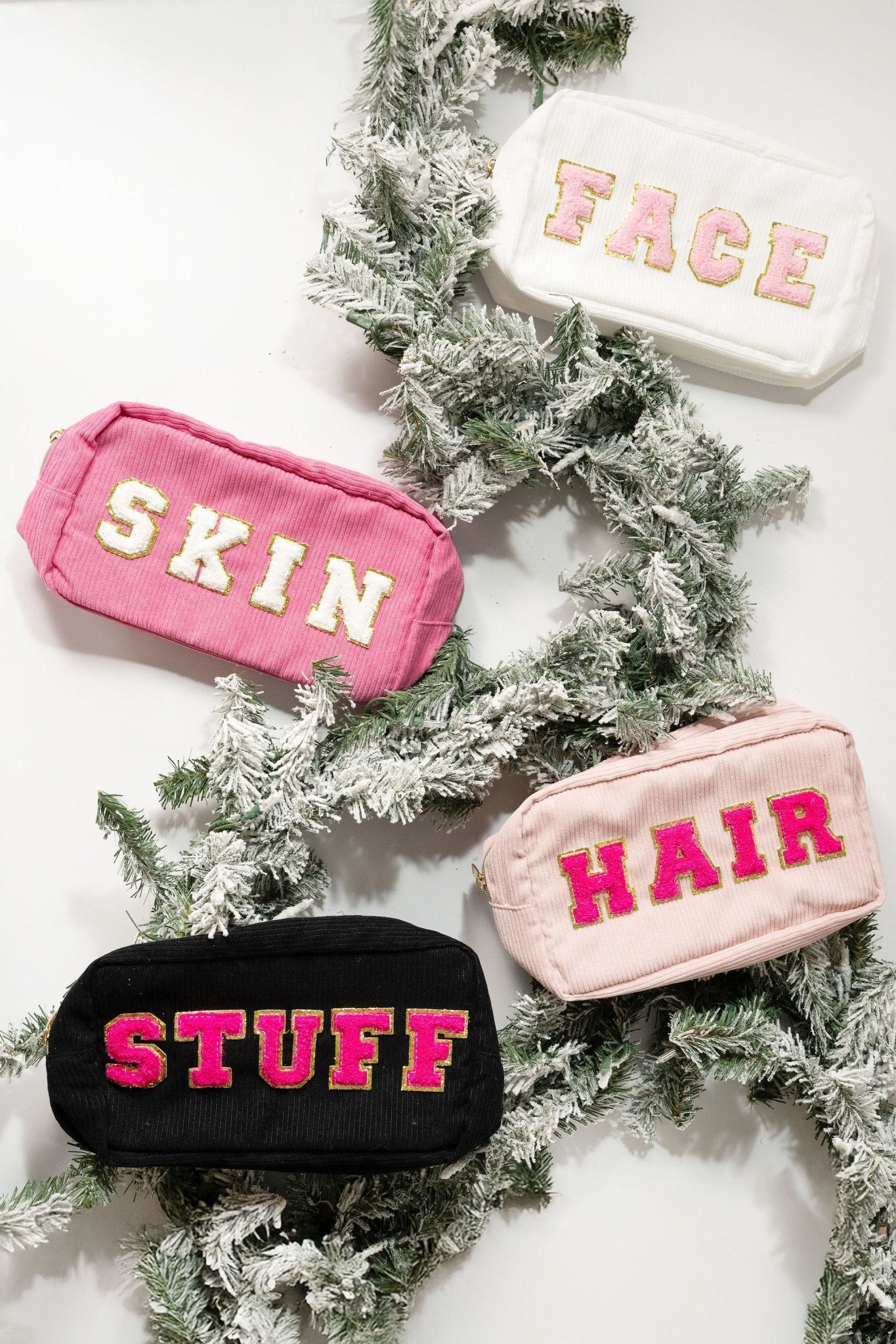 Four Multi Mix Patch Make Up Bags—labeled FACE, SKIN, HAIR, STUFF—rest on snow-dusted pine branches.
