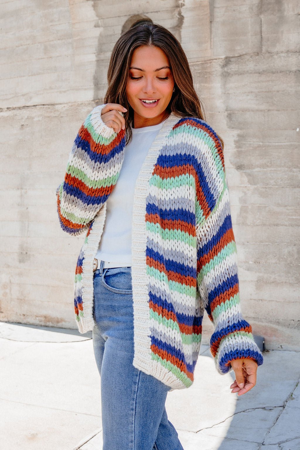 Model in Multi Striped Open Front Sweater Cardigan over white top and blue jeans, styled outdoors for fall layering.
