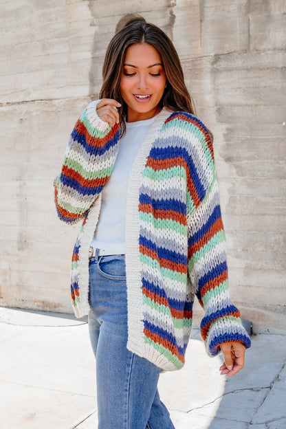 Model in Multi Striped Open Front Sweater Cardigan over white top and blue jeans, styled outdoors for fall layering.