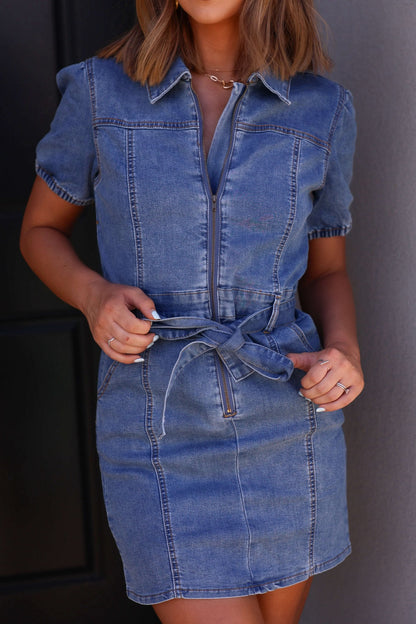 Woman wears the Myka Denim Belted Mini Dress, a short-sleeve zip-up style—perfect for country concerts.