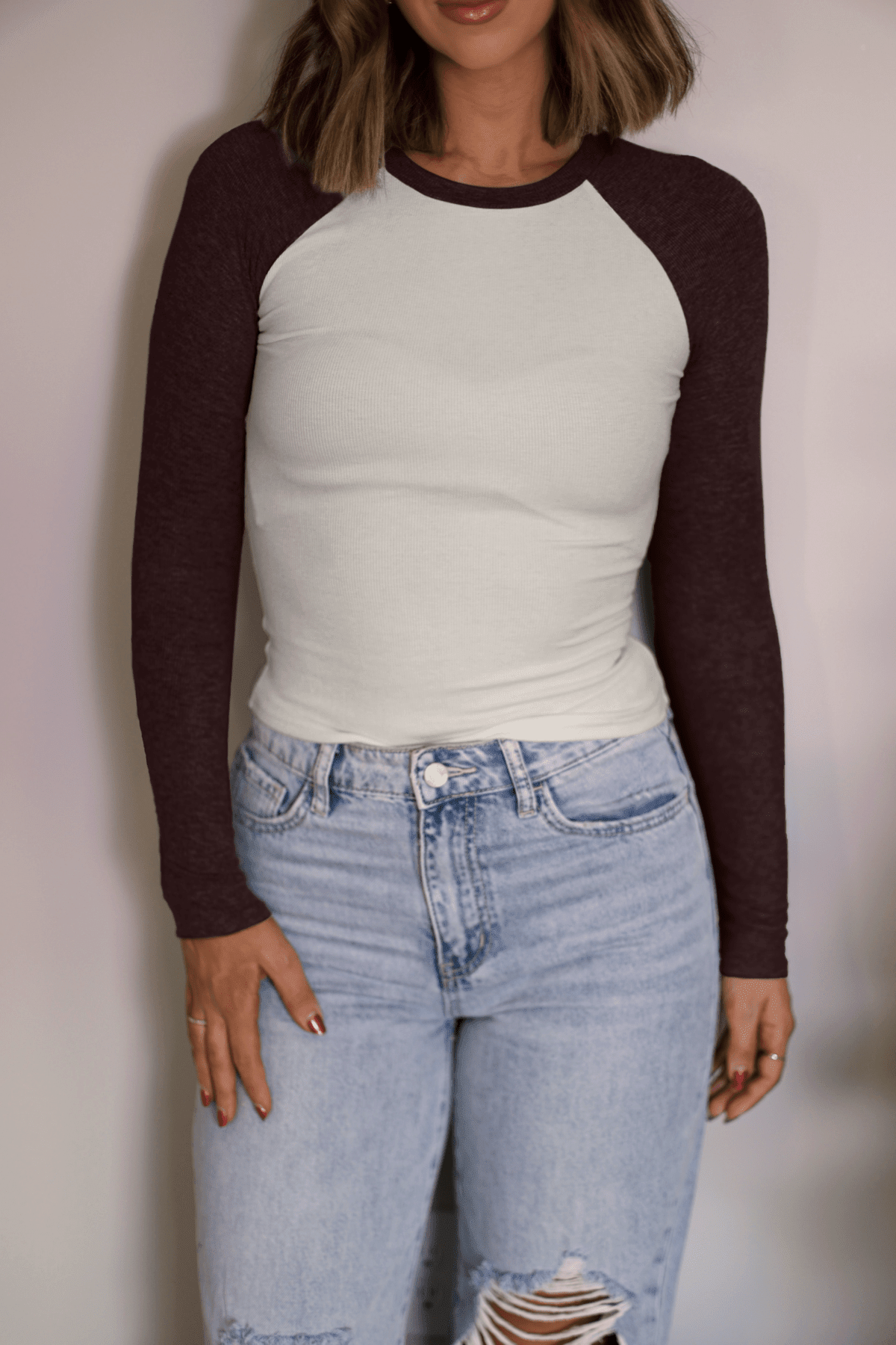 Woman in a Natalie Brown Color Block Tee with light blue ripped jeans, a casual staple for your everyday wardrobe.