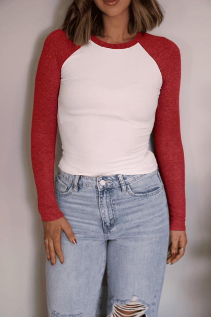 Woman wears the Natalie Red Color Block Tee with light blue ripped jeans—a versatile, casual look on a plain background.