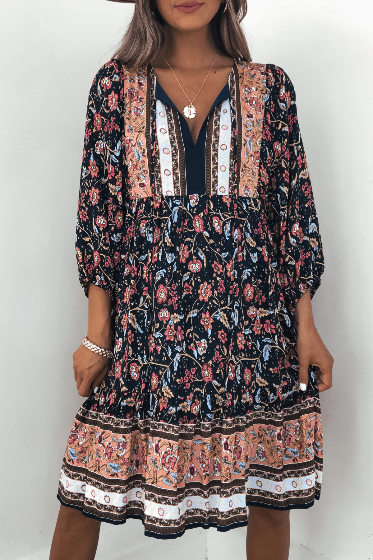 Woman in Navy Floral Border Print Mini Dress - FINAL SALE, with long sleeves and V-neck—perfect for fall.